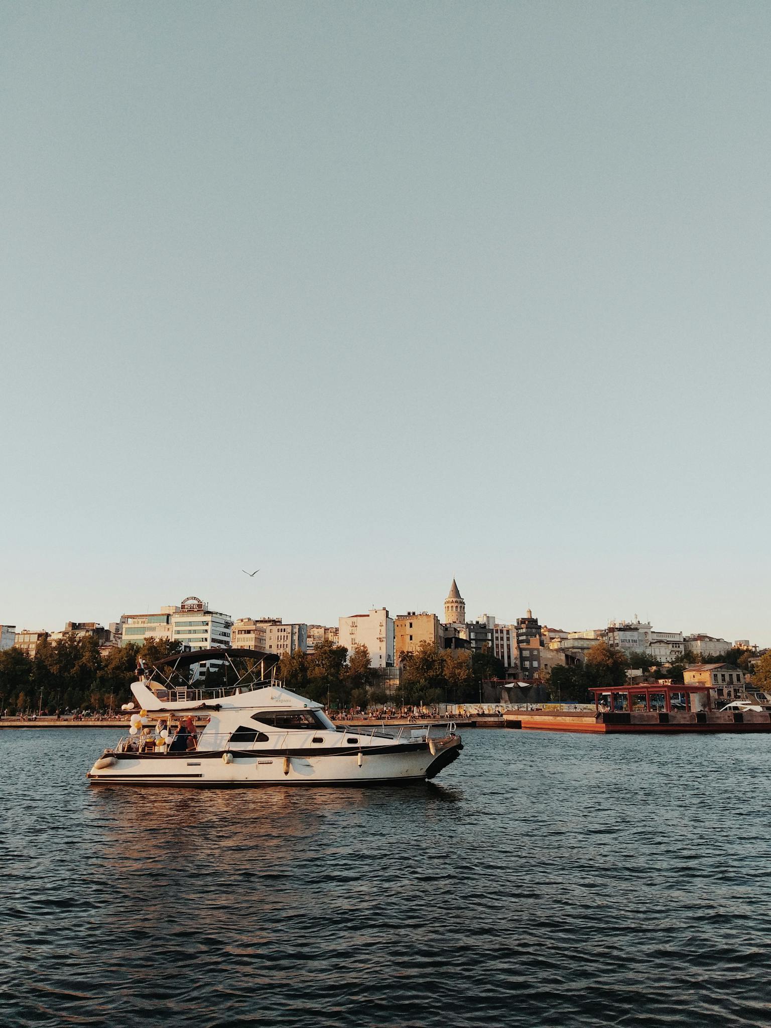 A white yacht cruising on the Bosphorus with Istanbul's iconic skyline in the background.